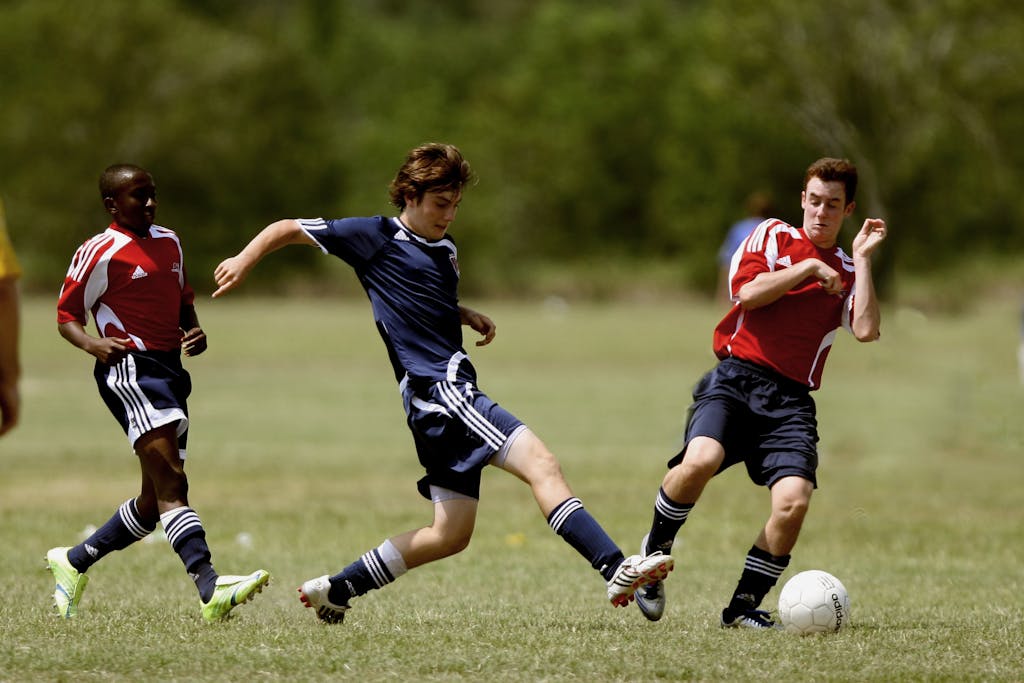 Teenage soccer players in action during an outdoor match showcasing skill and competition.